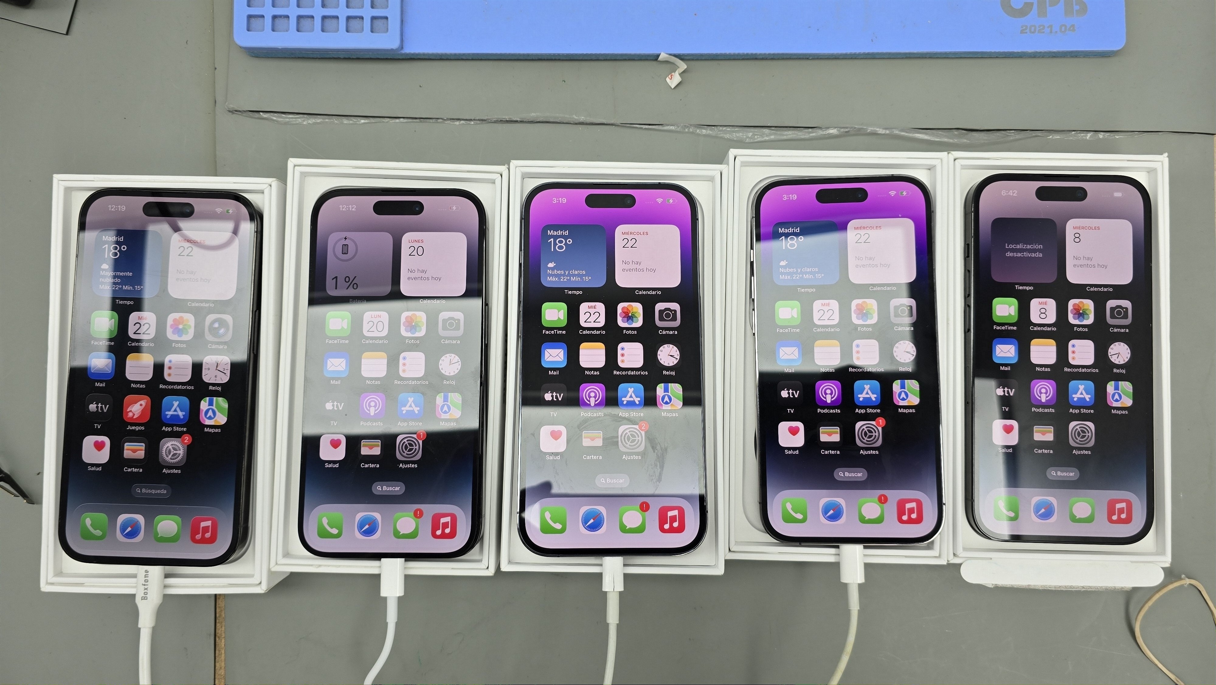 Cinco iPhones en fase de prueba y carga tras reparación
